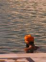 Sikh pilgrims take a holy dip in the temple pond before visiting the temple across the bridge.